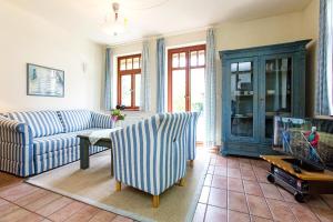 a living room with a couch and a tv at Ferienhaussiedlung Strandperlen Buchenhof 5a (Typ IV) in Wustrow