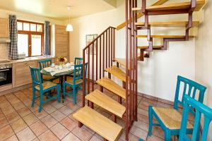 a dining room with a table and chairs and a staircase at Ferienhaussiedlung Strandperlen Buchenhof 5a (Typ IV) in Wustrow