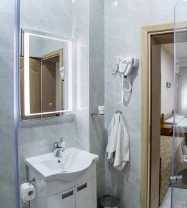 La salle de bains est pourvue d'un lavabo et d'un miroir. dans l'établissement B&B Passage, à Sremska Mitrovica