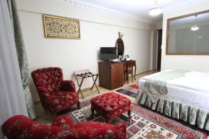 a hotel room with a bed and two chairs and a television at Basileus Hotel in Istanbul