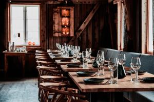 a long table in a restaurant with wine glasses at Holmen Lofoten in Sørvågen