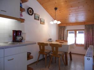 a kitchen with a table and chairs in a room at Urblhof in Leutasch