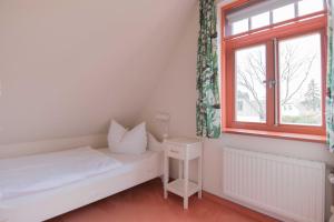 a small bedroom with a bed and a window at Ferienhaussiedlung Strandperlen Buchenhof 3a (Typ III) in Wustrow