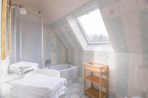 a bathroom with a sink and a bath tub at Ferienhaussiedlung Strandperlen Buchenhof 3a (Typ III) in Wustrow +11 photos