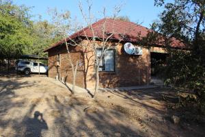 uma pequena casa de tijolos com um carro em frente em Umhlanga Kruger em Marloth Park