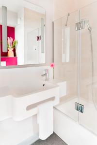 a white bathroom with a sink and a shower at B&B Hôtel in Magny-le-Hongre