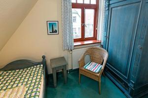 a bedroom with a bed and a chair and a window at Ferienhaussiedlung Strandperlen Weidenhof 2a (Typ III) in Wustrow