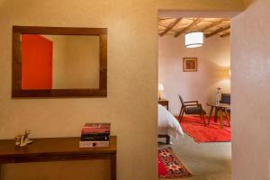 um quarto com uma cama, um espelho e uma sala de jantar em Côté Sud em Uarzazate