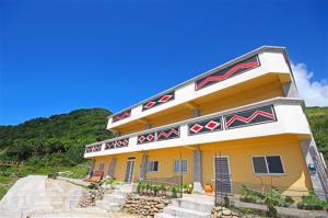a yellow building with a sign on top of it at Banai Homestay in Lanyu