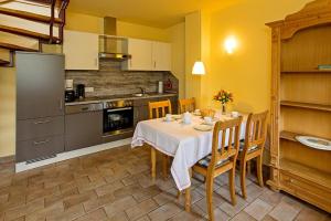 een keuken met een tafel met een witte tafeldoek bij Ferienhaussiedlung Strandperlen Weidenhof 3c (Typ II) in Wustrow