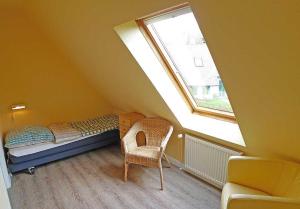 a small attic room with a bed and a window at Ferienhaussiedlung Strandperlen Weidenhof 3c (Typ II) in Wustrow