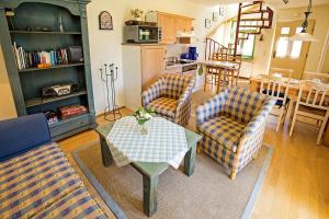 a living room with two chairs and a table at Ferienhaussiedlung Strandperlen Sanddornhof 3d (Typ I) in Wustrow