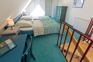 a small bedroom with a bed and a staircase at Ferienhaussiedlung Strandperlen Sanddornhof 3d (Typ I) in Wustrow