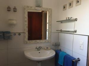 y baño con lavabo, espejo y toallas azules. en Casa Laguna ET0490 en La Savina