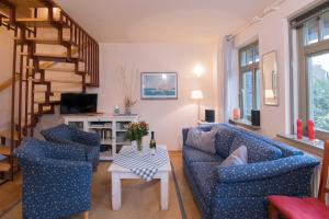 uma sala de estar com dois sofás azuis e uma escadaria em Ferienhaussiedlung Strandperlen Sanddornhof 7a (Typ VIII) em Wustrow