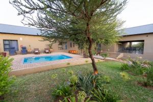 a yard with a swimming pool and a tree at Asuite-Dream in Hoedspruit