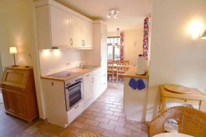 a kitchen with white cabinets and a counter top at Ferienhaussiedlung Strandperlen Sanddornhof 8b (Typ IX) in Wustrow