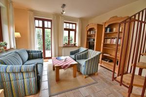 a living room with two couches and a table at Ferienhaussiedlung Strandperlen Sanddornhof 2c (Typ II) in Wustrow