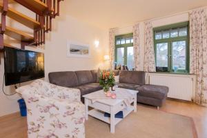 ein Wohnzimmer mit Sofa und Tisch in der Unterkunft Ferienhaussiedlung Strandperlen Sanddornhof 3a (Typ VIII) in Wustrow
