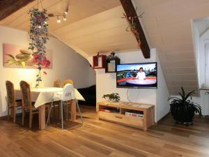 ein Esszimmer mit einem Tisch und einem TV an der Wand in der Unterkunft Altes Forsthaus in Bad Peterstal-Griesbach