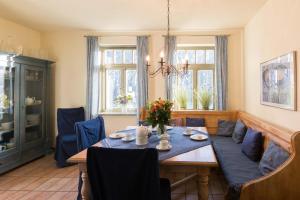 een eetkamer met een tafel en blauwe stoelen bij Ferienhaussiedlung Strandperlen Küstenhof 4a (Typ IX) in Wustrow