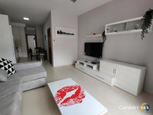 sala de estar con sofá y TV de pantalla plana en Intimate and Stilysh Apt, PKG, Self Entry by Canary365, en Tenoya