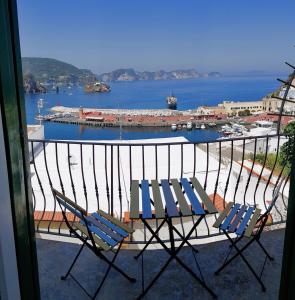 a balcony with two chairs and a view of a harbor at Maridea - Camere con vista al Porto in Ponza