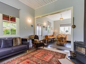 - un salon avec un canapé et une cheminée dans l'établissement The Red Rooster Cottage, à Raurimu Spiral