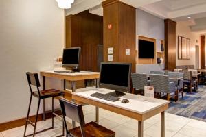 a waiting room with two computer monitors on a desk at Holiday Inn Express Hotel & Suites Toronto - Markham, an IHG Hotel in Richmond Hill