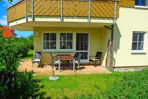 a house with a patio with a table and chairs at BIRKENHOF Whg. BH-41 in Wustrow