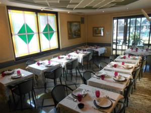 a dining room with tables and chairs and windows at Hotel Valdaso in Pedaso