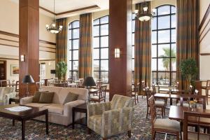 eine Hotellobby mit Tischen, Stühlen und einem Sofa in der Unterkunft Staybridge Suites El Paso Airport, an IHG Hotel in El Paso