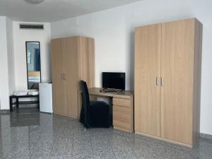 an office with a desk with a computer and wooden cabinets at Hotel Santa Giulia in Castenedolo