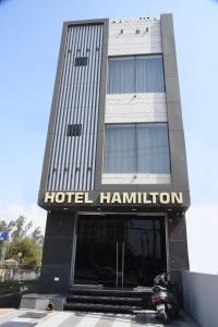 een hotelgebouw met een motorfiets ervoor geparkeerd bij Hotel Hamilton in Zirakpur