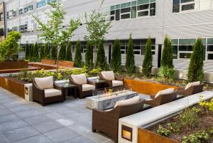 un patio con sillas, mesas y una hoguera en EVEN Hotel Seattle DTWN Lake Union, an IHG Hotel, en Seattle
