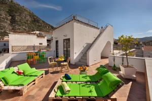 een patio met groene meubels op een dak bij YourHome - Karme House in Meta