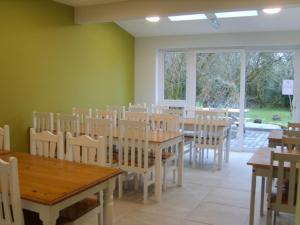 a dining room with wooden tables and chairs at The Benwiskin Centre in Ballaghnatrillick