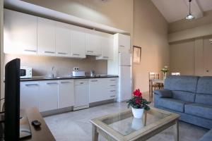 a kitchen and a living room with a couch and a table at Apartamentos Turísticos La Castilleja in Córdoba