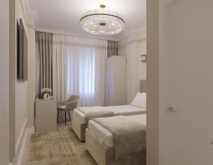 a hotel room with two beds and a chandelier at Lumiere Boutique Hotel in Moscow