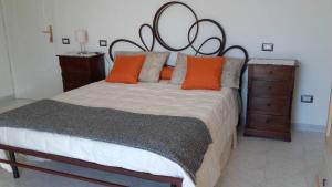 una camera da letto con un grande letto con cuscini arancioni di La Casa in Vigna a Tramonti