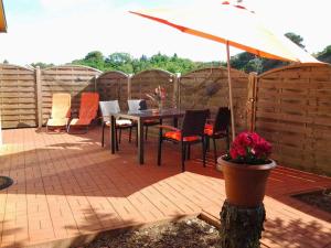 a patio with a table and chairs and an umbrella at Ferienhaeuser Zinnowitz USE 3420 in Zinnowitz