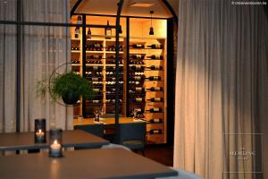 a dining room with a wine rack with wine bottles at The Memlinc in Knokke-Heist