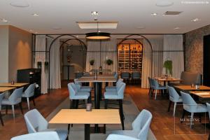 a restaurant with tables and chairs in a room at The Memlinc in Knokke-Heist