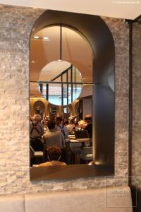 un miroir dans un restaurant avec des personnes assises à table dans l'établissement The Memlinc, à Knokke-Heist