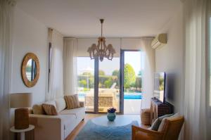 a living room with a couch and a view of a pool at Atlantis Gardens in Mazotos