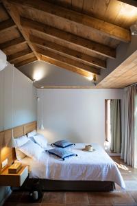 Schlafzimmer mit einem großen Bett und Holzdecken in der Unterkunft Klaritz Luxury Suites in Lassi