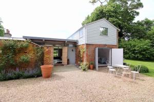 ein Haus mit einem Garten mit Stühlen und einem Kühlschrank in der Unterkunft Sky Room, Rendham (Air Manage Suffolk) in Saxmundham