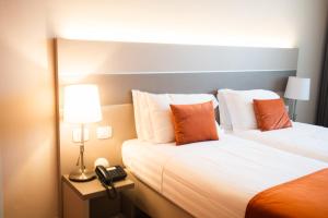 ein Hotelzimmer mit 2 Betten und einem Telefon in der Unterkunft Hotel Glis in San Mauro Torinese