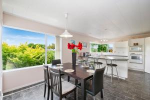eine Küche und ein Esszimmer mit Tisch und Stühlen in der Unterkunft The White House - Taupo Holiday Home in Taupo