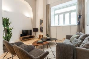 salon z kanapą, krzesłami i telewizorem w obiekcie FLH Cais Sodré Design Duplex - Ribeira 11 w Lizbonie